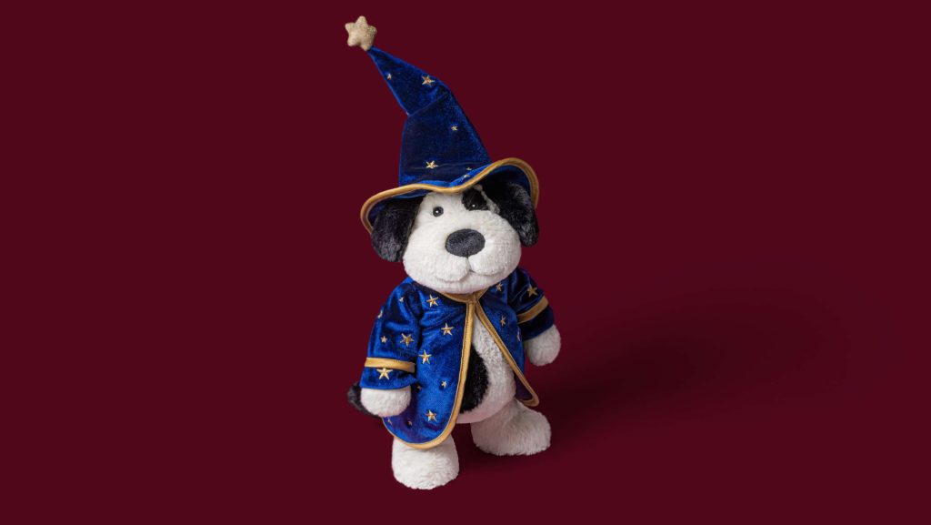 Jellycat Puppy in a wizard outfit with a burgundy background